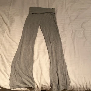 Grå mjukisbyxor från Gina Tricot - Grå mjukisbyxor från Gina Tricot med bred resår i midjan och utsvängda ben. Byxorna är i mjukt och stretchigt material, perfekta för en avslappnad stil.