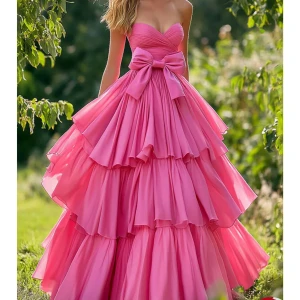 Rosa balklänning  - Drömmig rosa långklänning med flera lager volanger och stor rosett i midjan. Axelbandslös design med hjärtformad urringning och omlott över bysten. Perfekt för bal eller festliga tillfällen. Storlek 44, skickar snabbt! 