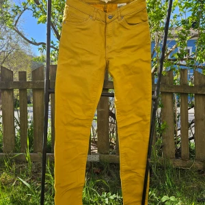 Gula skinny jeans - Snygga gula jeans med skinny passform och klassisk femficksdesign. Byxorna har normal midja och stängs med dragkedja och knapp. Perfekta för att liva upp din outfit med en färgklick.