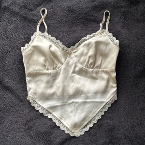 Justerbar topp - En ljus beige topp med spets detaljer på kanterna. En liten osynlig drakkedja på sidan för lättare påtagning och justerbara band. Skriv vid frågor ☺️