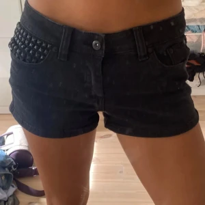 Svarta lågmidjade  jeansshorts - Snygga svarta jeansshorts med coola nitar på fram och baksida!  