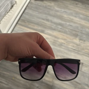 Svarta solglasögon med lila tonade glas, väldigt lika raybans boyfriend - Stilrena solglasögon med svart, fyrkantig båge och lila tonade glas. Passar dig som gillar en klassisk men ändå modern look. Perfekt accessoar för soliga dagar.