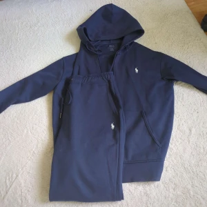 Mörkblå hoodie från Polo Ralph Lauren - Mörkblå tracksuit från Ralph Lauren. Det är från deras 2024 kollektion. Storlek M på båda. Inget OG följer med. Nypris för båda: 3995kr. Mitt pris är 999kr för båda. Tracksuiten har lagt ut på liknade platformer så skriv innan köp. Skambud blockeras. Byte kan vara utav intresse. PM för mer info.