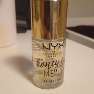 NYX Honey Dew Me Up Primer - NYX Honey Dew Me Up Primer med guldlock och genomskinlig flaska. Primern är gelbaserad och innehåller små guldfärgade partiklar. Kommer med en applikator i locket för enkel applicering. Är lite använf och skriv om du har frågor, säljer då jag inte använder primer längre😊❤️