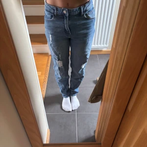 Blå slitna jeans från Kids Only - Säljer ett par blå jeans från Kids Only i storlek 164. Jeansen har normal passform, hög midja och slitna detaljer på benen. Klassisk femficksmodell med knapp och dragkedja framtill. Finns resorband i midjan så man kan spänna in och även lite ut! Stryker innan de postas. Läs gärna bio💘