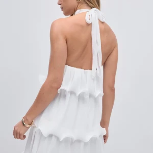 Vit omlottklänning med volang - Superfin vit klänning med halterneck och volangdetaljer som är helt slutsåld på gina tricot. Klänningen har öppen rygg och knyts i nacken. Endast använd en gång, som ny 