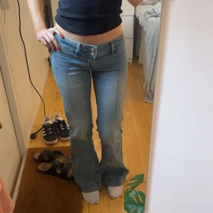 Ljusblå bootcut jeans - Säljer ett par ljusblå jeans med bootcut passform och låg midja. Jeansen har klassisk femficksdesign, dragkedja och knapp framtill. Perfekta för dig som gillar stockholmsstil och vill ha ett par snygga jeans till vardags.