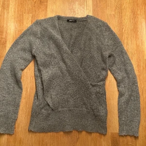 Grå omlottkofta från Gina Tricot - omlottkofta från Gina Tricot stickad, Koftan har långärmade ärmar, ribbad nederkant och en snygg omlottfront. ❤️