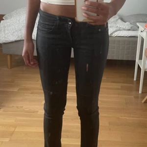 Svarta skinny jeans G-Star Raw - Säljer ett par svarta skinny jeans från G-Star Raw, modell Midge Skinny WMN. ‼️Bild 1 är missvisande pga det ser ut som hål - det är spegeln som är smutsig ‼️Jeansen har låg midja. Det finns ett justerbart band på baksidan för att tajta till vid midjan. Man kan klä upp den med fest topp, blir riktigt snyggt!