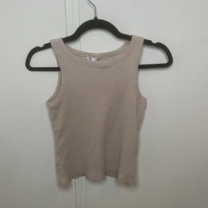 Beige ribbad linnetopp från Cubus - Säljer en beige ribbad linnetopp från Cubus i storlek S. Toppen är ärmlös med rund halsringning och har en mjuk, stretchig känsla.