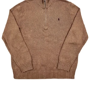 Beige Polo Ralph Lauren - Snygg beige stickad tröja från Polo Ralph Lauren med halv dragkedja och broderad logga på bröstet. Tröjan har ribbade muddar och hög krage, perfekt för lager-på-lager under hösten och vintern. Klassisk och stilren modell som funkar till allt.