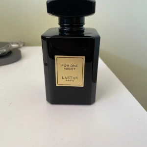 For One Night parfym från Lastar Paris - Snygg parfymflaska i svart glas med guldig etikett, For One Night från Lastar Paris. Flaskan rymmer 55 ml och har en stilren, fyrkantig design med svart lock. Perfekt för dig som gillar exklusiva och eleganta dofter.
