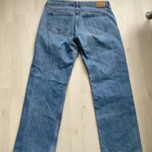 Weekday Arrow ljusblå straight jeans - Säljer ett par Weekday Arrow jeans i ljusblå tvätt med rak passform och låg midja. Klassisk femficksmodell med snygga kontrastsömmar. Perfekta för dig som gillar en avslappnad och tidlös look.