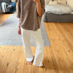 Vita linnebyxor från H&M - Snygga vita linnebyxor från H&M i storlek 32. Byxorna har hög midja, vida ben och knytband i midjan. 