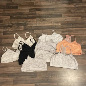 Set med sportiga linnetoppar - 10 stycken toppar i vitt, svart och persikofärgat. Några har spetsdetaljer i ryggen och smala axelband, andra är enkla med stretchig passform. Perfekta för träning eller chill. Materialet är mjukt och elastiskt, blandning av polyester och elasten.