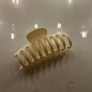 Krämvit hårklämma i plast - Snygg och enkel hårklämma i krämvit färg med klassisk form och breda taggar som håller håret på plats. Perfekt för att snabbt fixa en chill frisyr eller sätta upp håret när du pluggar eller hänger med kompisar.