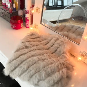 Offwhite pälsponcho från Soyaconcept - Supermjuk och fluffig offwhite poncho från Soyaconcept. Randigt mönster i pälsen och är gjord i syntetmaterial som känns lyxigt. Perfekt att slänga över en hoodie eller stickad tröja för en trendig lager-på-lager-look.