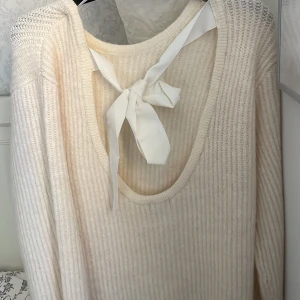 Vit stickad tröja med rosett i ryggen - Mysigt snygg stickad tröja från Gina tricot. Endast använd 1 gång.