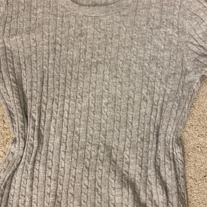 Grå tunn stickad tröja Gina Tricot - Grå kabelstickad tröja från Gina Tricot, tröjan passar som S om man föredrar en mindre tight tröja, perfekt för hösten.