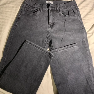 Grå jeans från Lindex straight fit - Snygga grå jeans från Lindex med klassisk femficksdesign och raka ben. Jeansen har normalhög midja och är tillverkade i mjukt bomullstyg med lite stretch för extra komfort. Perfekta till en avslappnad streetstyle-look.