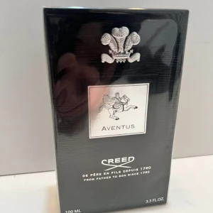 Creed Aventus parfym 100ml - Exklusiv Creed Aventus parfym i svart och silver förpackning, 100 ml. Lyxig doft med ikonisk design och silverdetaljer, perfekt för dig som vill sticka ut med en klassiker från ett anrikt parfymhus.