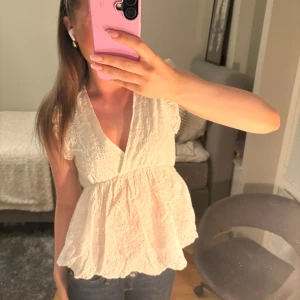 Söt vit topp - Supersöt vit blus med broderade detaljer och volangkant. Djup v-ringning och ärmlös design med små volanger på axlarna. Använd men bra skick💞