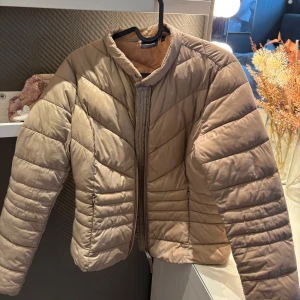 Beige pufferjacka med dragkedja - Säljer en beige pufferjacka från Vero Moda i storlek S. Jackan har dragkedja framtill och 2 sidofickor med dragkedja. Den är även i mycket bra skick!