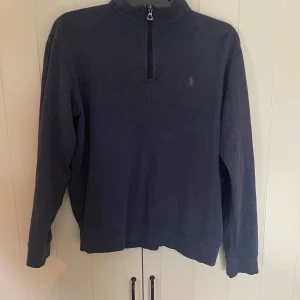 Blå half zip tröja från Polo Ralph Lauren - Säljer nu min polo tröja som är i väldigt bra skick då den inte passar längre. Själv tycker jag att tröjan är väldigt bekväm och fin. Köptes ny i England för runt 2000kr. Storlek 170, Small