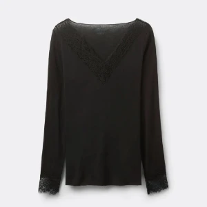 Svart intimissimi topp - Stilren svart långärmad blus med v-ringning och fina spetsdetaljer både vid halsringningen och ärmsluten. Perfekt för dig som gillar en enkel men ändå elegant look.