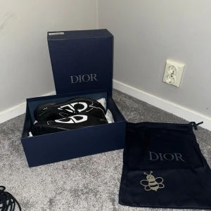 Svarta Dior B30 sneakers - Säljer ett par svarta Dior B30 sneakers med vita och grå detaljer. Skorna har en chunky sula, mesh och skinnpaneler samt stora reflekterande CD-loggor på sidorna. Klassisk snörning och sportig vibe, levereras med originalkartong och dustbag.