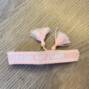 Dior armband - Rosa Christian Dior armband med justerbara tofsar. Armbandet kostar 130 kr och inga förhandling eller prisförslag. 