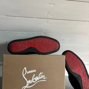 Christian Louboutin  - Svarta sneakers från Christian Louboutin. Skorna är använda mycket och där med ganska slitna. Går att fräschas upp! Box med tillbehör medföljer! Tveka inte på att höra av dig om du har frågor.
