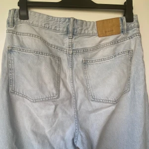 Ljusblå raka jeans från bershka - Säljer ett par ljusblå jeans från Monki med klassisk femficksdesign och raka ben. Jeansen har hög midja och är tillverkade i mjukt bomullsjeansmaterial. Perfekt för dig som gillar en chill och avslappnad stil.