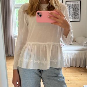 Vit broderad blus från H&M - Superfin vit blus från H&M i storlek 38, men jag skulle säga att den är mer som en xs-S. Jag själv brukar ha xs.  Blusen har broderade detaljer vid halsringningen och på ärmarna, samt en volang nedtill💕