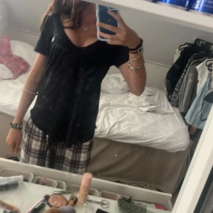 Svart v-ringad t-shirt Abercrombie - Svart t-shirt från Abercrombie & Fitch med v-ringning och korta ärmar. Klassisk passform och mjukt bomullsmaterial. Liten vit logga med älg broderad på bröstet. 