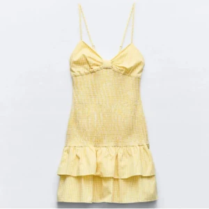 Gul zaraklänning - Supersöt gul kortklänning från Zara med smala axelband, volangkant och rosett i ryggen. Storleken är i M men passar bra på mig som brukar ha XS/S. Klänningen är i fint skick och knappt använd!