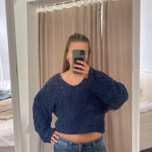 Mörkblå croppad stickad tröja C - Säljer en mörkblå croppad stickad tröja från Cubus i storlek S. Tröjan har breda, långa ärmar och snyggt kabelstickat mönster längs ärmarna. V-ringad hals och loose passform ger en chill vibe. Perfekt att matcha med jeans eller kjol för en cool look.