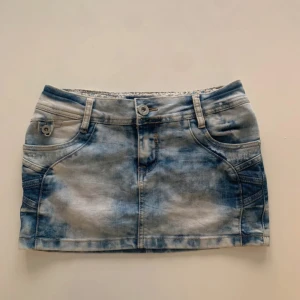 Blå jeanskjol med slitna detaljer - ❗️INTRESSEKOLL❗️Snygg kort jeanskjol med låg midja från DRM i ljusblå och vit tvättad denim. Kjolen har klassiska fickor fram och bak, slitna detaljer på bakfickorna och hällor för bälte. Perfekt för dig som gillar en cool och avslappnad stil. Skriv innan ni köper🩷midjemått är ca 35 cm 🩷 pris kan diskuteras 