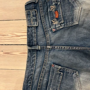 Blåa jeans - Snygga blå jeans från Modern Jeans med slitna detaljer och broderade fickor bak. Säljer då byxorna aldrig används. midja ca 40 cm, innerbenslängd ca 70cm, ytterbenslängd ca 93 cm🤍🤍 Kan diskutera pris