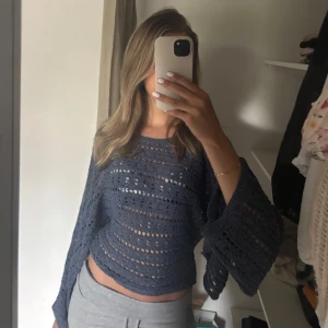 Mörkblå stickad tröja från Zara - Säljer en mörkblå stickad tröja från Zara med hålmönster och vida ärmar. Perfekt för lager-på-lager och ger en trendig look. Tröjan är luftig och har en avslappnad passform. Har endast använt ett fåtal gånger!! Perfekt nu när de börjar bli varmare väder att ha utanpå ett linne eller ha som strandkläder. Underärmarna är öppna❤️ Köpte den för ca 350kr och den är som ny❣️