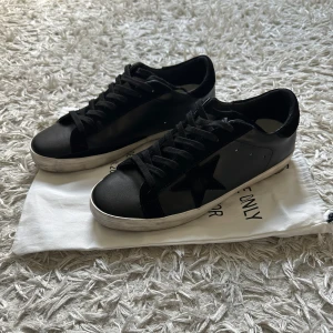GOLDEN GOOSE ~ svarta lädersneakers - Säljer ett par tvärfeta läder golden goose sneakers i svart. Skorna är helt nya och dustbag och extra sulor medföljer. Skorna är aldrig använda och lädret har  varken nån crease eller skrapa. Skosulorna är som sagt aldrig använda. Säljer pga för lite storlek. Hör av er vid minsta intresse! 