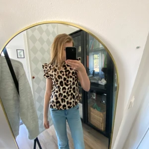 Leopardmönstrad topp med volangärmar från SHEIN - Säljer en snygg topp från SHEIN med leopardmönster och volangärmar. Toppen har rund halsringning och är tillverkad i ett lätt syntetmaterial. Storlek XS\S !🐆🐆🐆