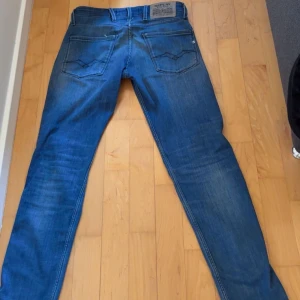 Blå Replay Anbass jeans - Säljer ett par klassiska blå jeans från Replay, modell Anbass. Jeansen är slim fit storlek är W27 L30. Skriv privat för fler bilder. Det är inga skador på jeansen 