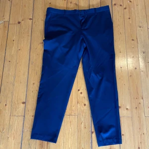 Mörkblå kostymbyxor - Snygga mörkblå kostymbyxor med klassisk rak passform och pressveck. Perfekta till en dressad look och har diskret knäppning i midjan. Stilrena och enkla att matcha med skjorta eller kavaj.
