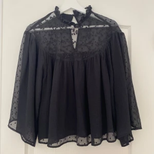 Svart blus med spets och volang - Säljer denna blus ifrån Zara med fina detaljer. Hör av er vid frågor eller för fler bilder!