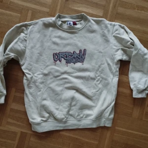 Beige sweatshirt från Red Roc Sport - Säljer en beige sweatshirt från Red Roc Sport med trycket 'Urban Sequence' i graffiti-stil på bröstet. Tröjan är tillverkad i 100% bomull och har långa ärmar samt ribbade muddar vid ärmslut och nederkant. Från tidigt tvåtusental.  Strl L youth, så typ S. 