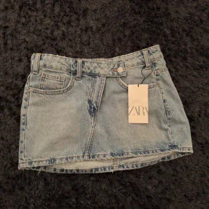 Zara jeanskjol  - Säljer min fina jeans kjol från zara. Säljs då den tyvärr har blivit för liten. Aldrig använd så lappen sitter kvar. Skriv för fler bilder eller lämna prisförslag! ❤️Ganska kort med en låg midja🥰