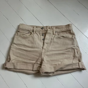 Beige jeansshorts med uppvik kant - Beige jeansshorts med fickor. Shortsen har uppvikta  kanter, men kan också vikas ner och ha en rå, fransig kant. Har hög midja och stängs med knappar. Perfekta för en avslappnad stil till sommaren. Skriv för fler bilder💞