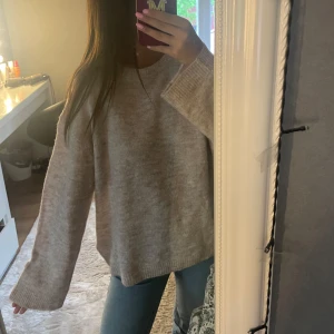Beige stickad oversized tröja - Mysig beige stickad tröja med rund hals och långa, vida ärmar. Tröjan har en avslappnad, oversized passform och är perfekt till lite kallare sommarkvällar. 🩷🩷🩷