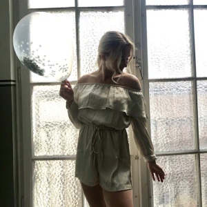 Offshoulder jumpsuit från Bubbleroom - Säljer en champagnefärgad offshoulder jumpsuit från Bubbleroom by Lovisa Barkman i storlek 34. Klänningen har långa ärmar, volang upptill och knyt i midjan. Perfekt för sommarens alla tillfällen!